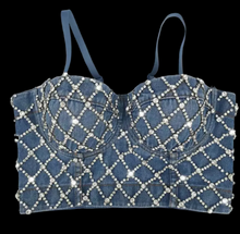 Denim top with rhinestone embellishments on a black background