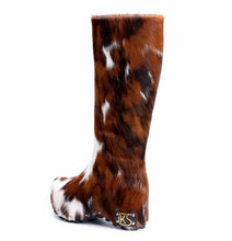 Brown and white cow print sock with a brand logo on a white background
