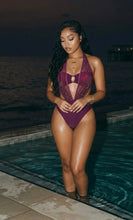 Model wearing luxury burgundy Désir Améthyste Monokini at poolside, elegant and feminine swimwear look