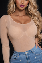 Woman wearing a beige sheer long-sleeve top and blue jeans against a black background
La Peau Illusion Mesh Bodysuit
bellarosecouture.com
