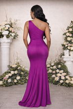 Woman in a purple evening gown standing in front of floral decorations.

La_Serpentine_One-Shoulder_Satin_Gown_with_Gold_Waist_Detail_Luxury_Evening_Dress