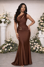 Woman in a brown dress standing in front of floral decorations
luxury gown, one-shoulder dress, satin evening gown, formal dress, ruched gown, gold waist detail, designer evening wear
