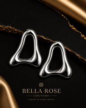 Close up of  Flux abstract silver earrings with a high shine mirror finish for Bella Rose Couture