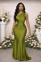 Woman wearing a green one-shoulder dress in a decorated indoor setting with flowers.

Light green satin one-shoulder evening gown with soft draping, body-contouring fit, and gold serpentine waist detail, styled for upscale events and refined formal looks.